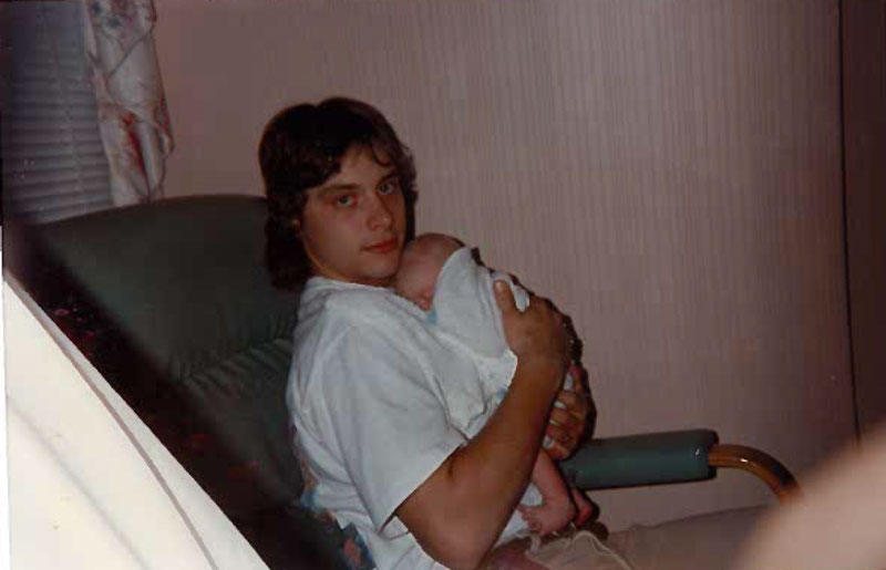 The innocent Chris holding his son Zachary as a baby